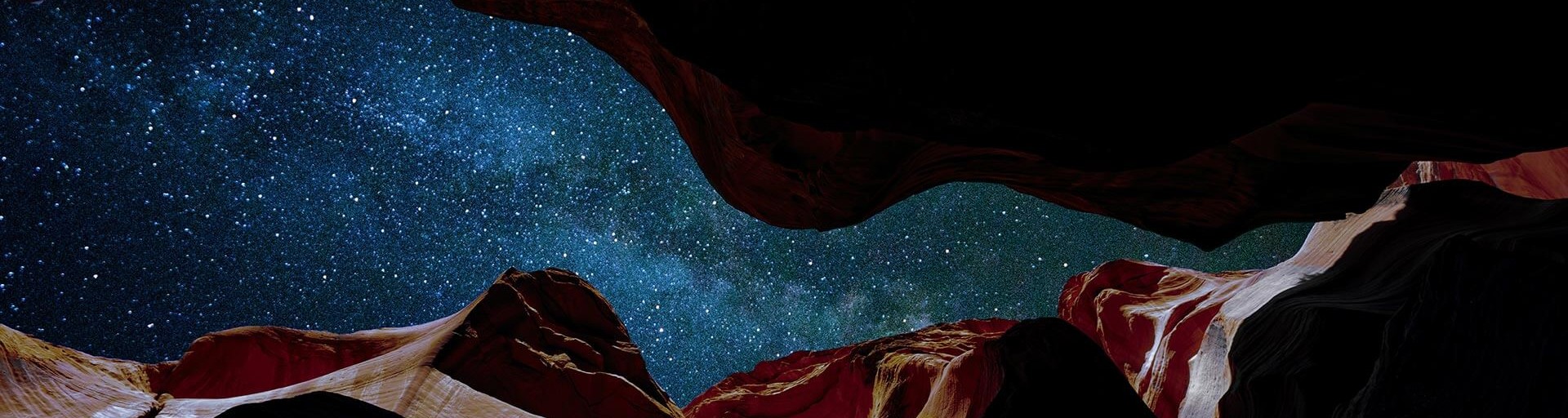 A view of a starry sky from inside a slot canyon