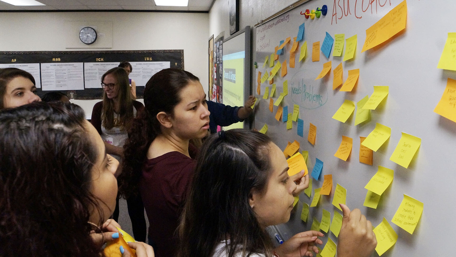 
		Washington Elementary teacher candidates put sticky notes on a whiteboard		