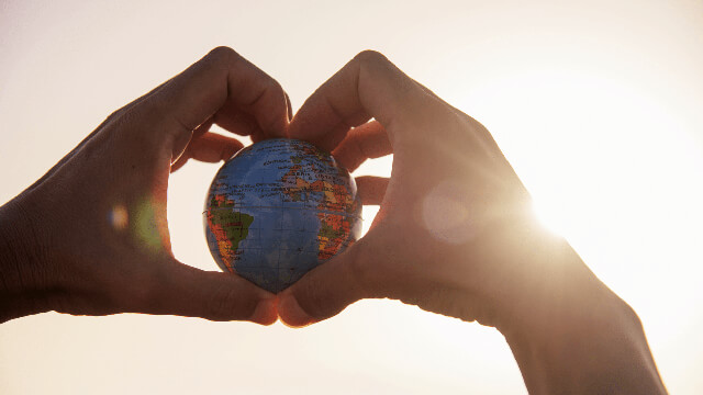 Hands holding a small globe