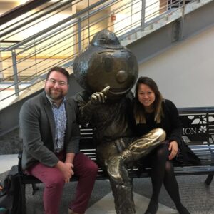 Ben Scragg and Christina Ngo with a bronze statue of the Ohio State University mascot, Brutus.