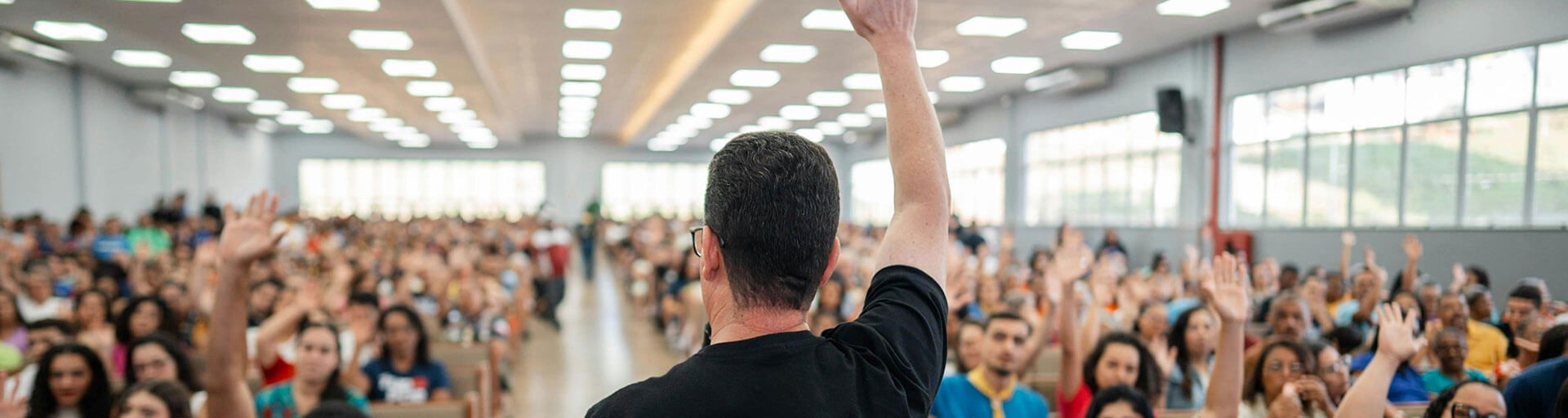 A man getting a "show of hands" vote from a crowd